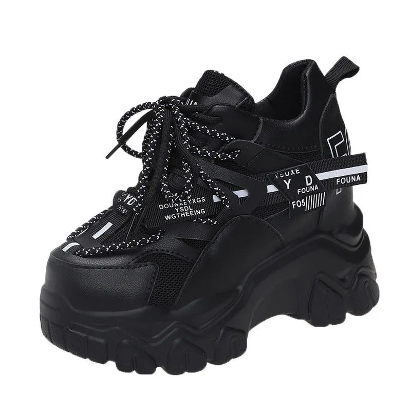 Women's white mesh platform sports shoe with cross strap and rubber sole on a neutral background.