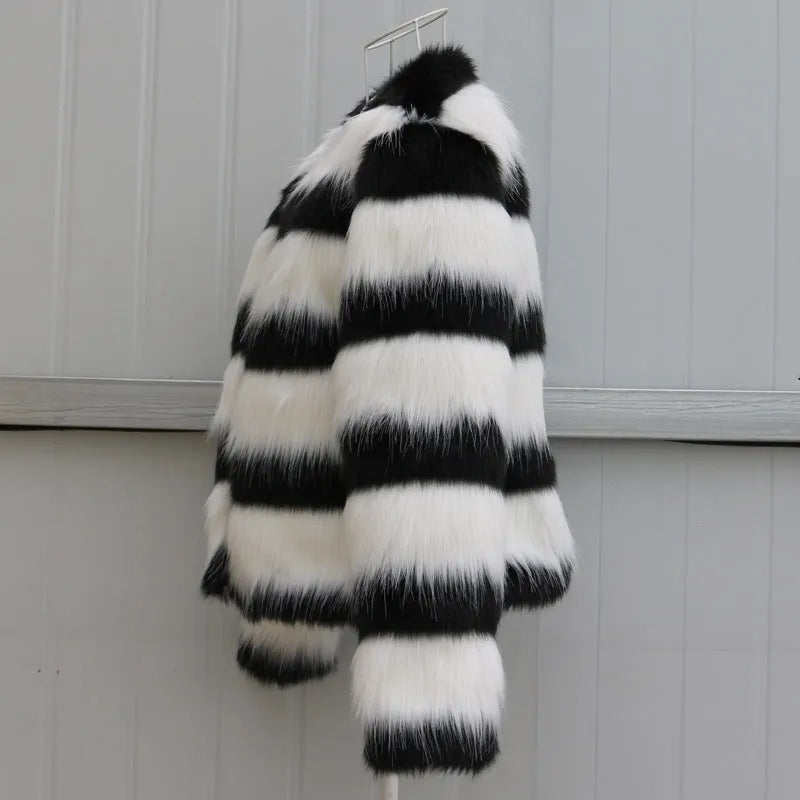 Women's long-sleeved black and white striped faux fur leather jacket on a hanger.