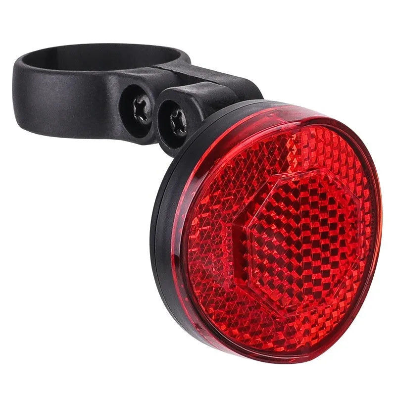 Red plastic anti-theft bicycle taillight bracket with integrated reflector mounted on a seat post.