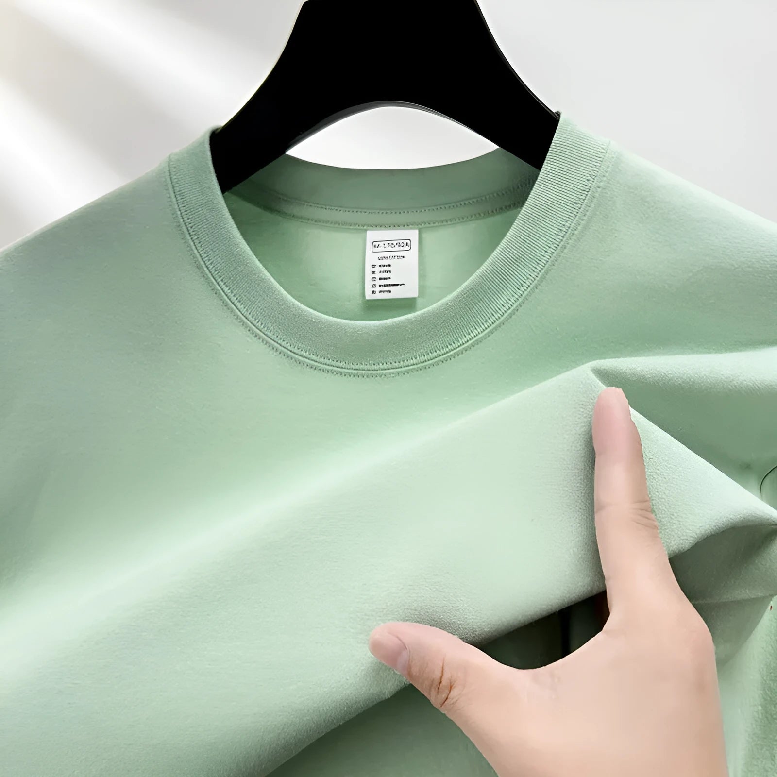 Men's solid colour cotton t-shirt with drop shoulder design on a hanger.