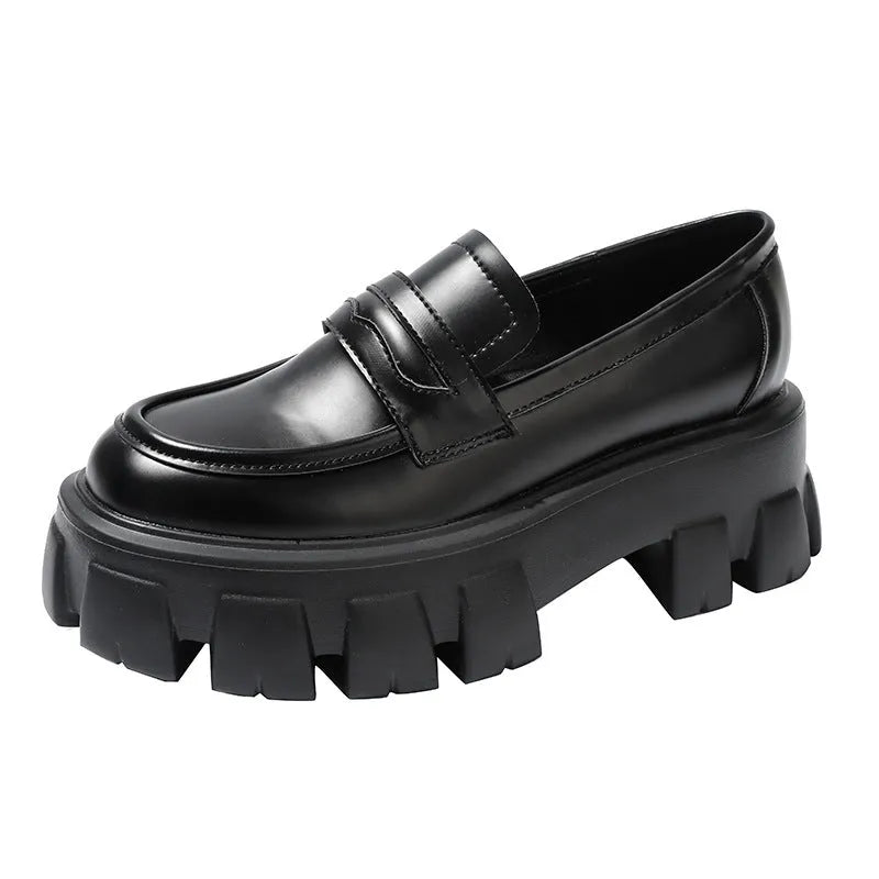 A pair of wide fit patent leather loafers with a flat rubber sole on a neutral background.