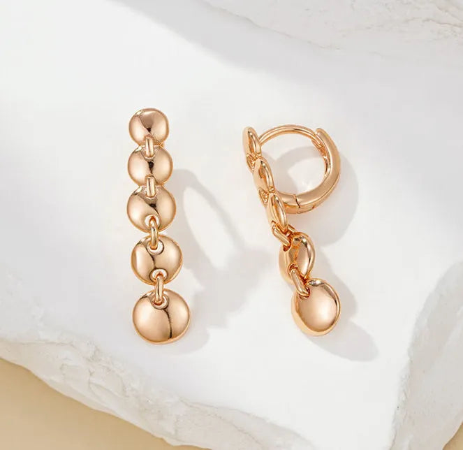 A pair of gold-coloured retro long round circle earrings with a woven copper design.