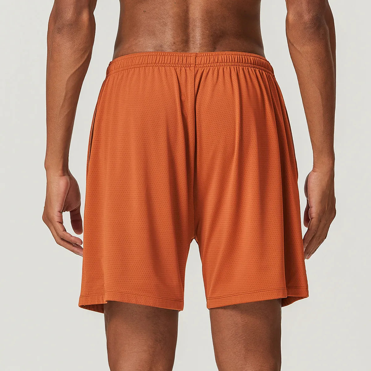Man wearing sky blue double-layer quick-drying running shorts with a mid-waist fit.