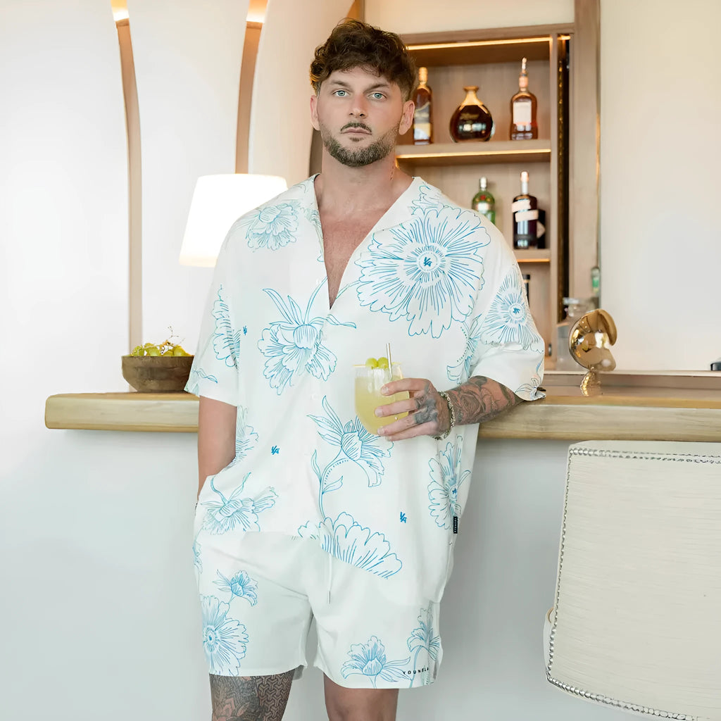 Man wearing a loose-fitting, short-sleeved printed top with a floral pattern in a neutral colour