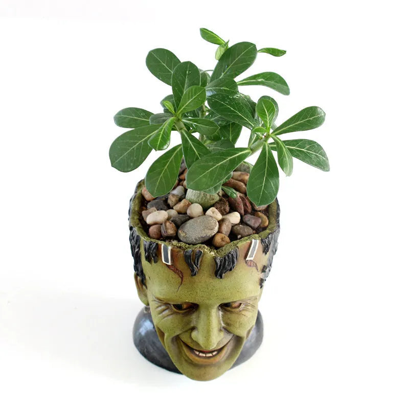 Green Man resin flower pot with sculptural relief detail on white desktop