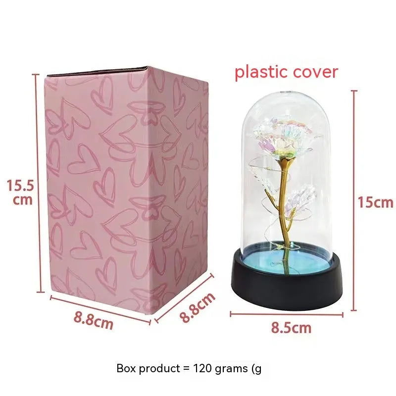 Small decorative night lamp with plastic flowers and a glass-style cover on a black base.