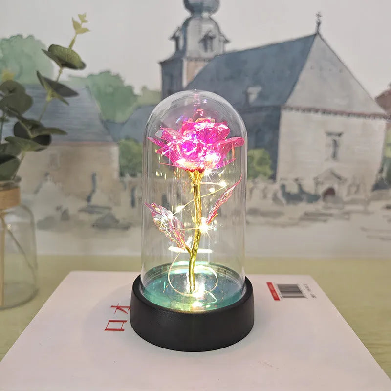 Small decorative night lamp with plastic flowers and a glass-style cover on a black base.