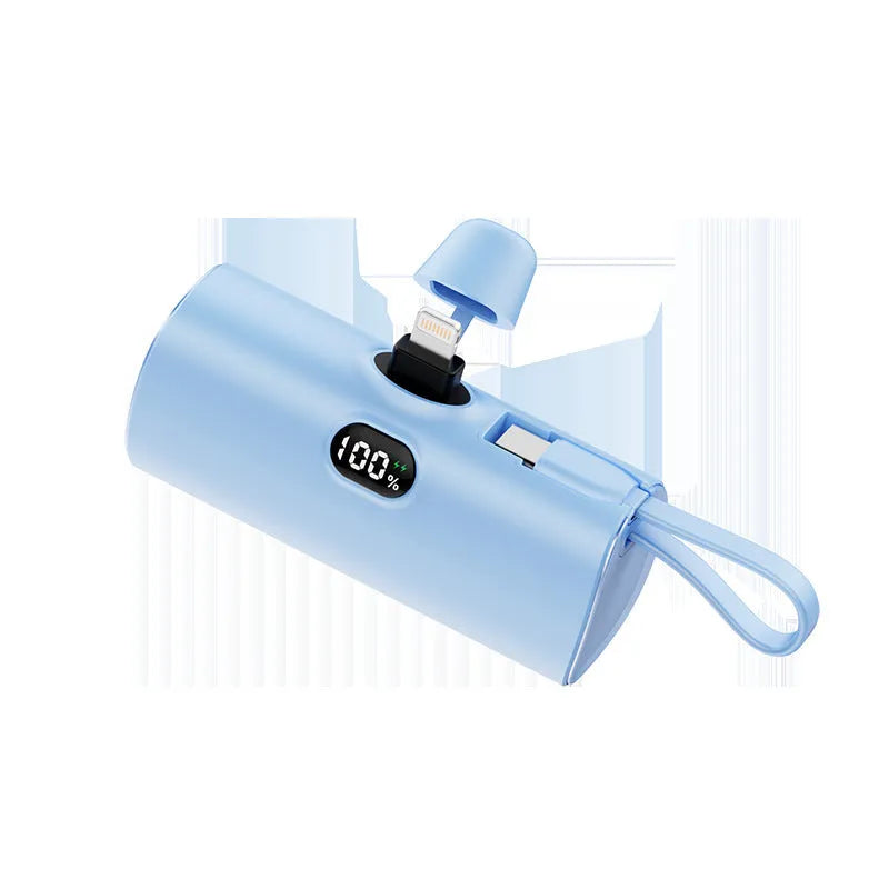 Colourful capsule-shaped power bank with digital display and a folding plug extended.
