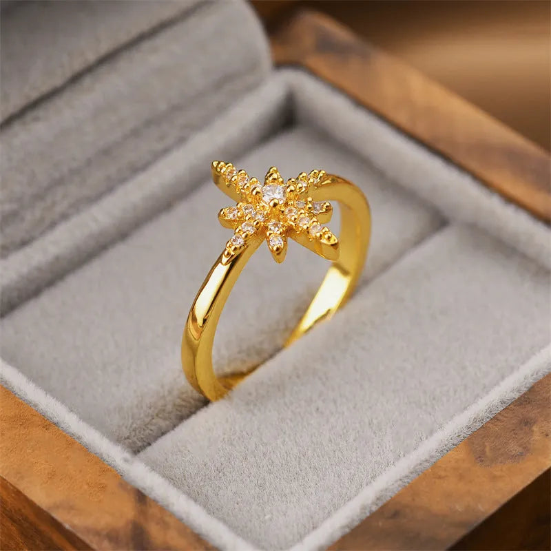 Gold-toned open-ended geometric women's ring on a neutral background, showing adjustable design.
