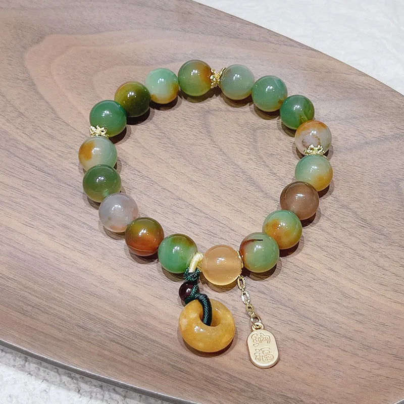 Yellow peacock agate and topaz beaded bracelet with a metal safety chain and peace buckle clasp.