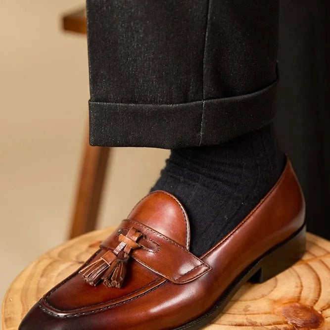 British-style leather tassel loafers in black or brown with polished uppers and traditional tassel detailing