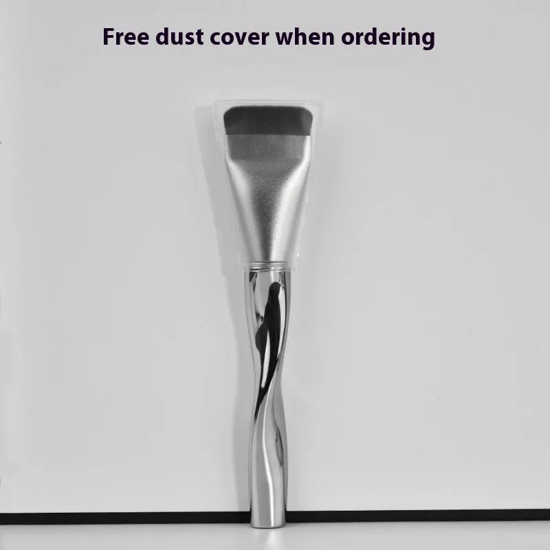 Spiral one-shaped black powder foundation brush with long handle on a white surface next to its storage bag.