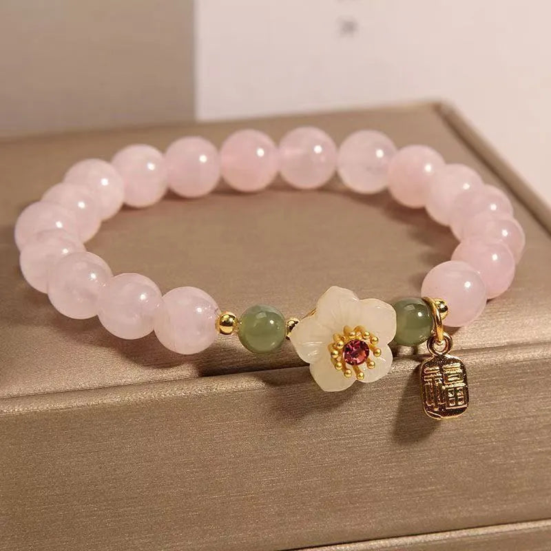 Crystal bracelet with Hetian jade beads showing peach blossom design, fruit charm, and camellia elements