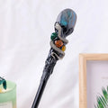 Natural crystal magic wand with labradorite stone ball on simple handle against neutral background