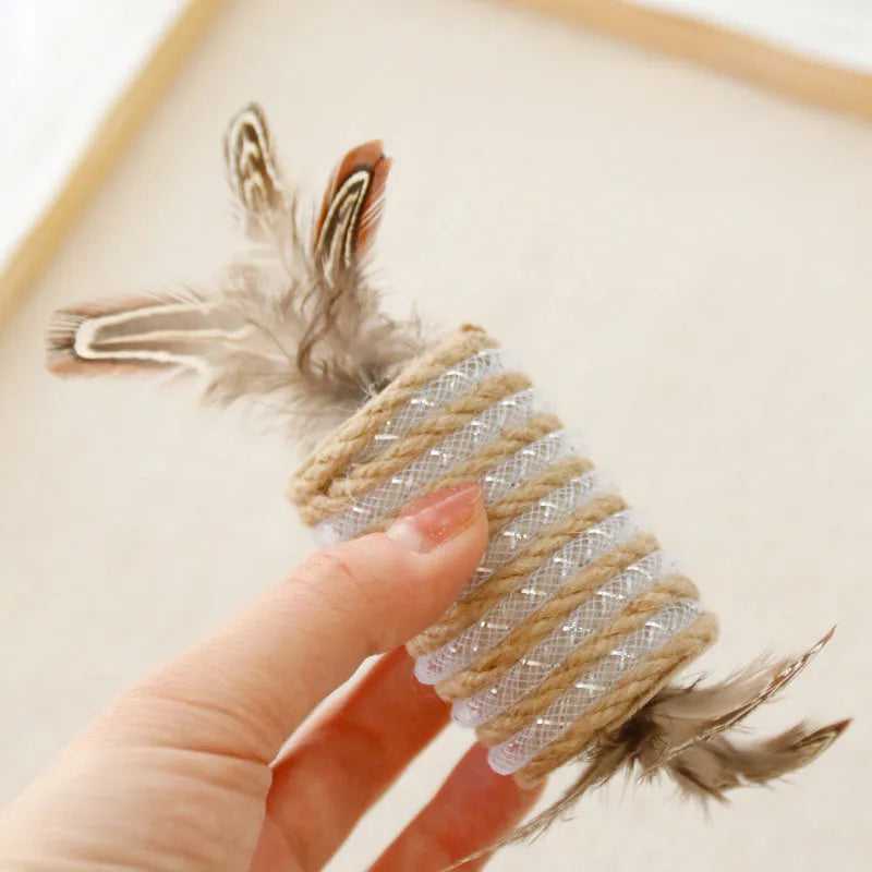 Beige interactive cat toy with hemp rope scratching post, colourful feathers, and a rolling sound mechanism.