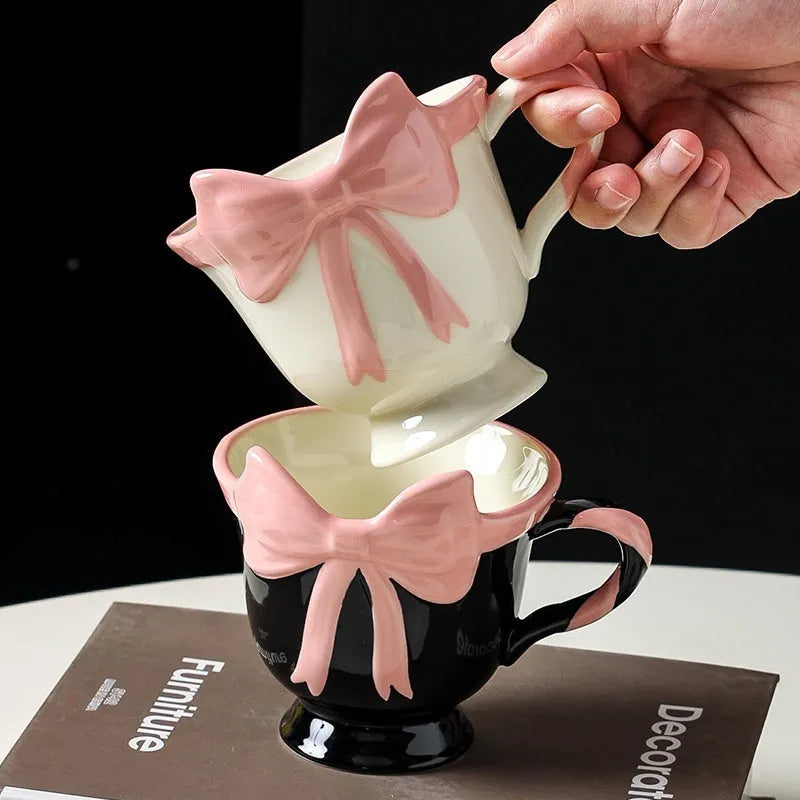 Ceramic mug with heart bow design in black pink and white powder colour options