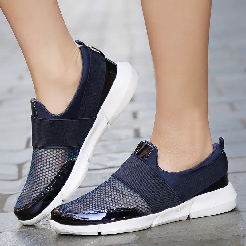 Blue women's low-top casual sneakers with mesh interior on a hard floor.