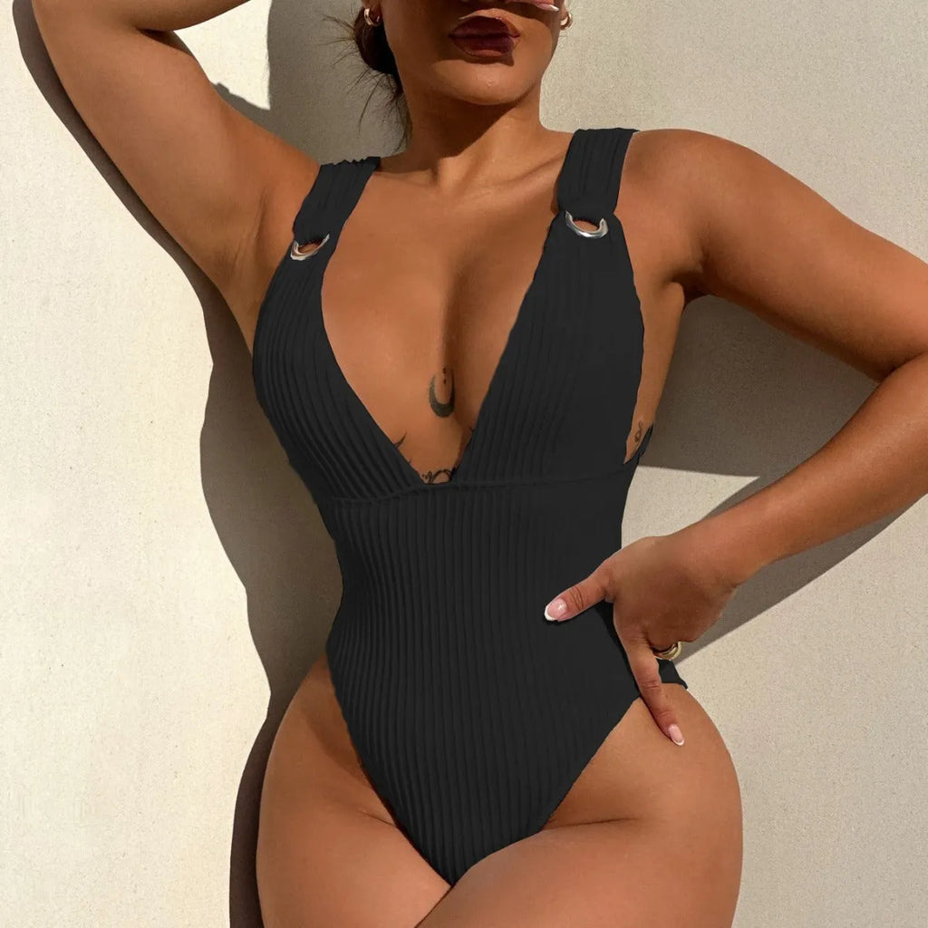Women's solid colour one-piece swimsuit on a hanger, available in black, white, green, and orange.