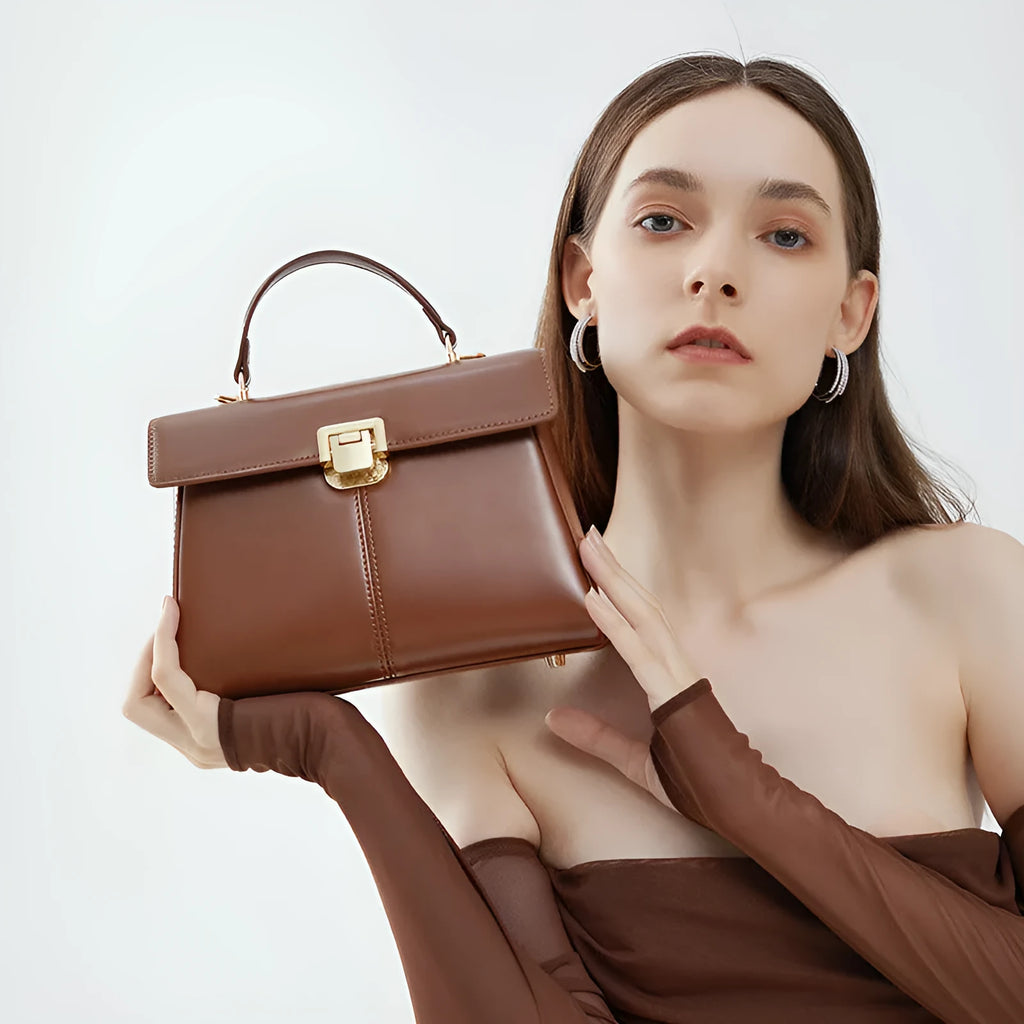 Black genuine leather women's shoulder bag with vachette clasp, showing horizontal square shape and adjustable strap.
