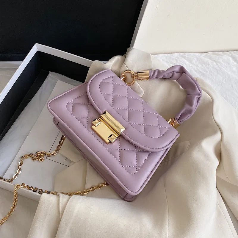 Purple Korean-style ladies square crossbody bag with soft PU texture on a table.
