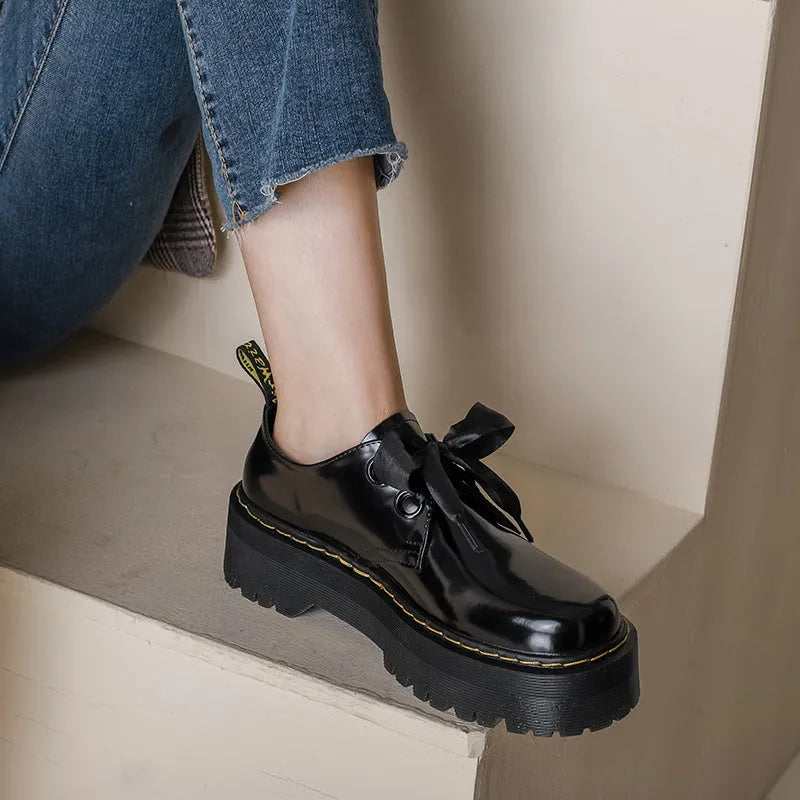 Women's white and black thick soled lace-up shoes with ribbon cross-straps on a superfine fibre upper.