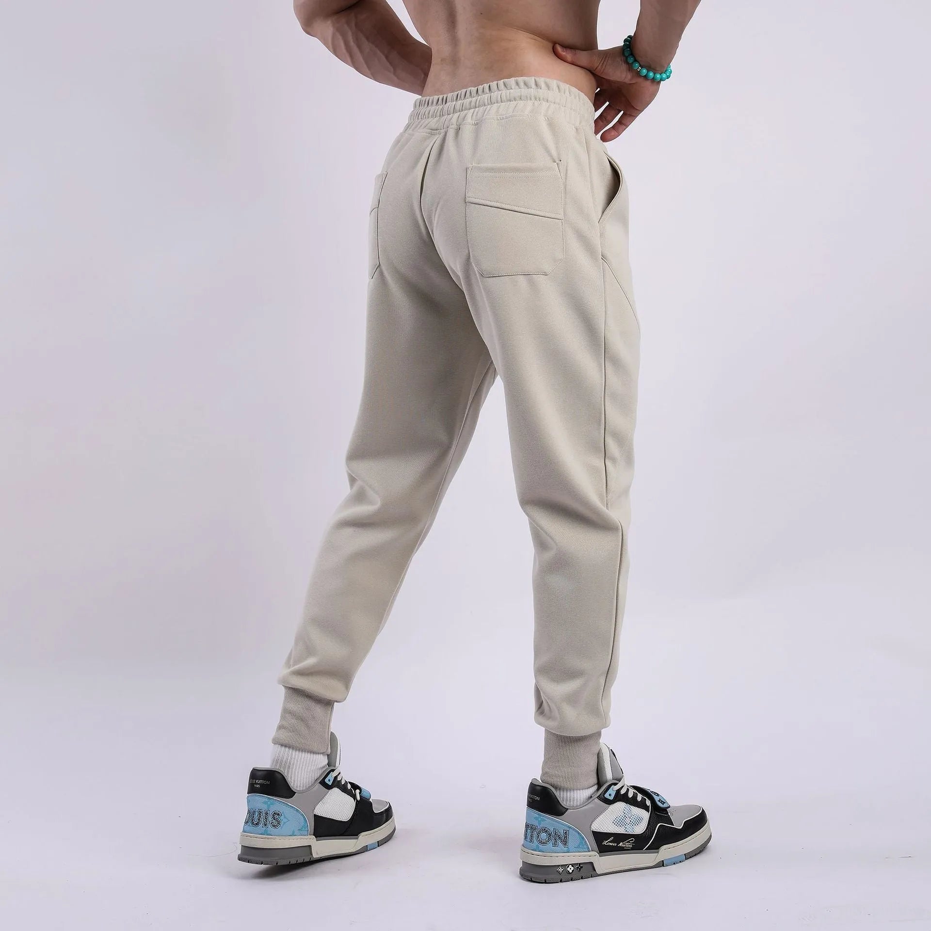 Man wearing grey ankle-tie drawstring sweatpants for casual leisure.
