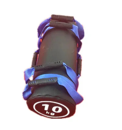 Flat white PVC fitness sandbag on gym floor, showing size and sturdy handles for weight training.