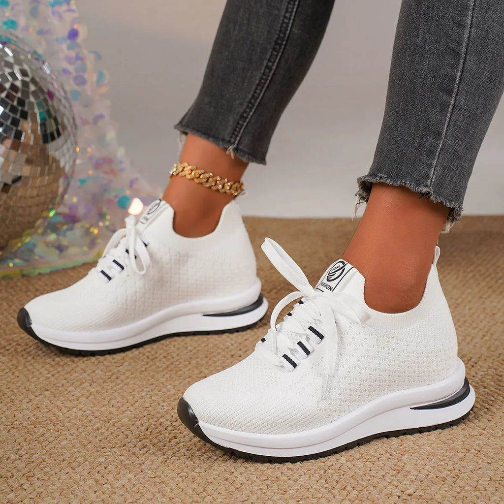 Women's black platform sneakers with mesh upper and lace-up front on flat rubber sole