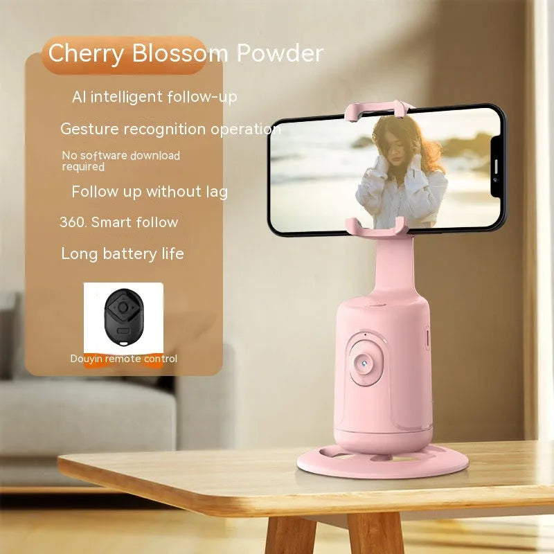 Automatic tracking stabiliser with 360-degree rotation in black, pink, and white on a desktop