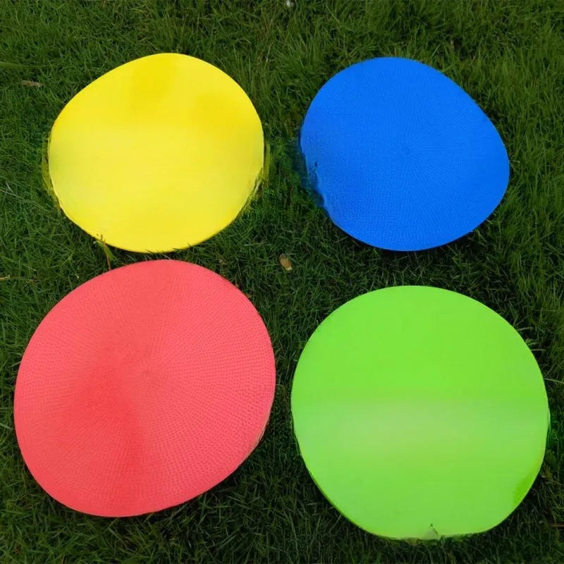 Soft yellow TPE football training target pad flat on grass, 23cm diameter.