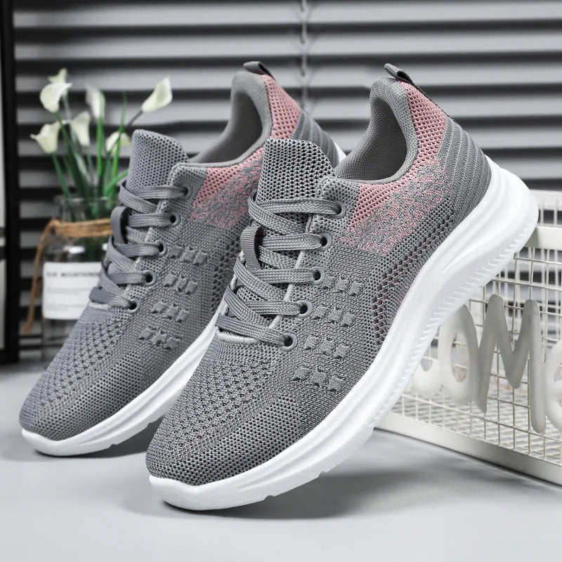 Women's low-top lace-up sneakers in black mesh with a round toe and soft PVC sole.