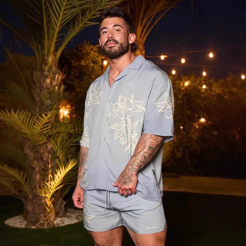 Man wearing a loose-fitting, short-sleeved printed top with a floral pattern in a neutral colour