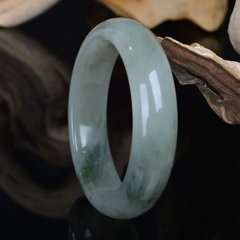 Natural Jinsi Jade Chinese style bracelet in a bangle shape on a plain background.