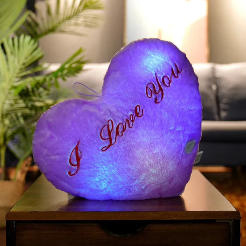 Colourful glowing five-pointed star plush pillow on a dark background, showing soft texture and LED illumination