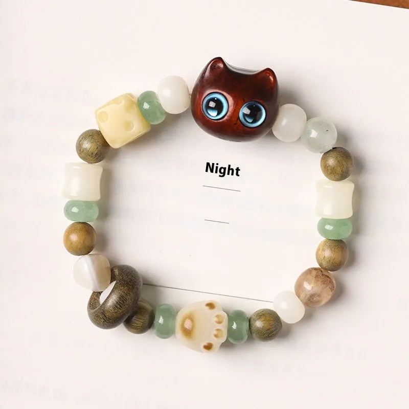 Hand-woven adjustable bracelet with bodhi seeds, jade beads, and a cartoon cat's paw guajacwood charm