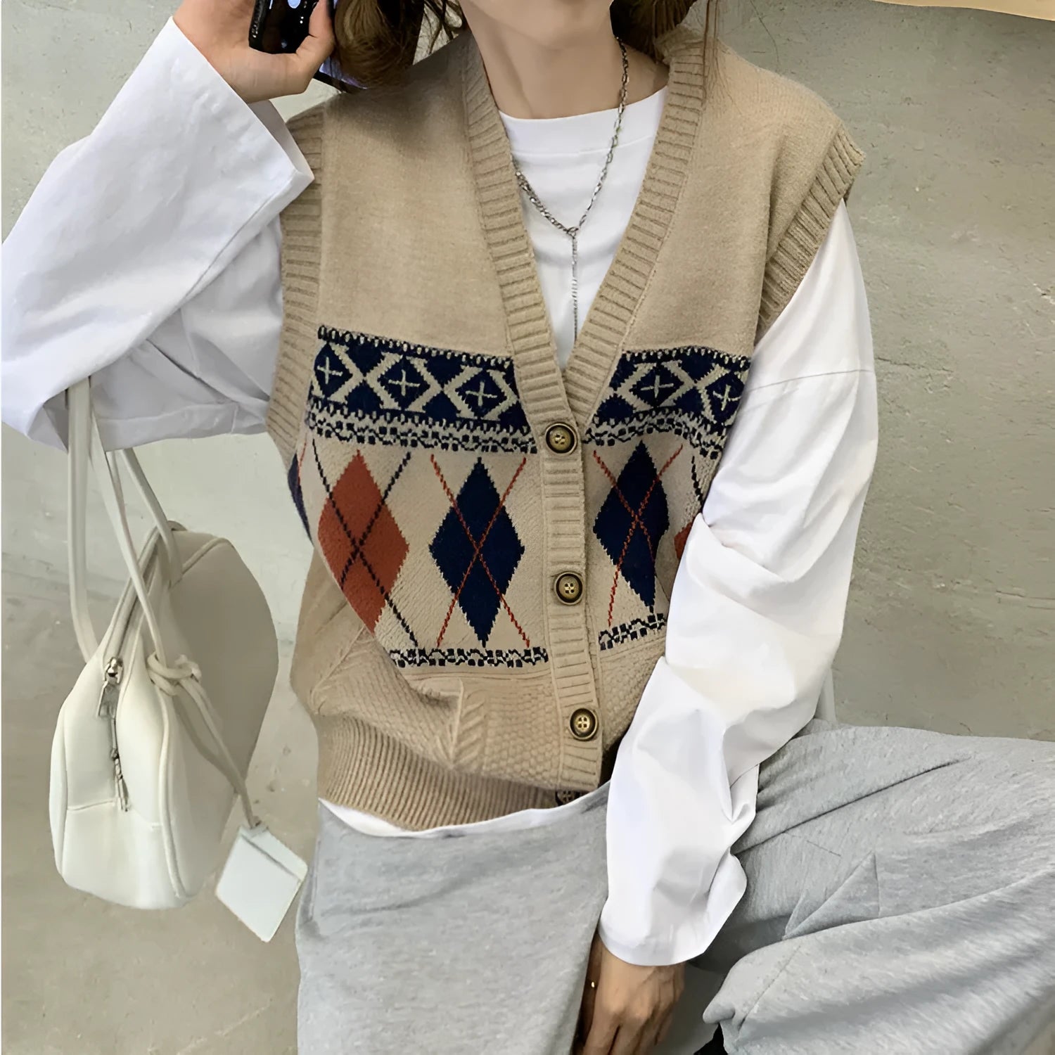 Khaki sleeveless loose cardigan top with diamond plaid pattern, open front.
