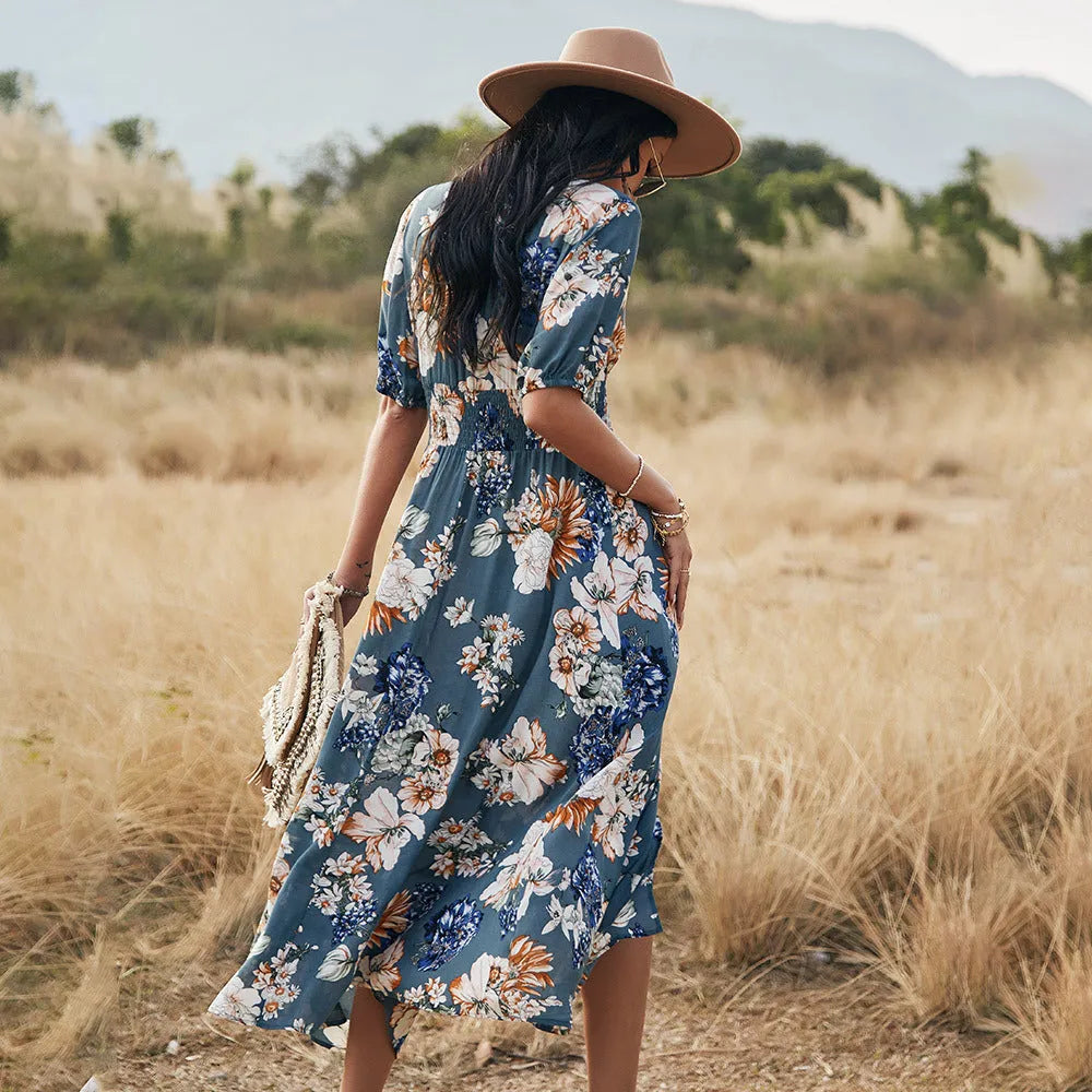 Yellow floral print dress on a hanger showing V-neck, short sleeves, elastic high waist, and full mid-length skirt.