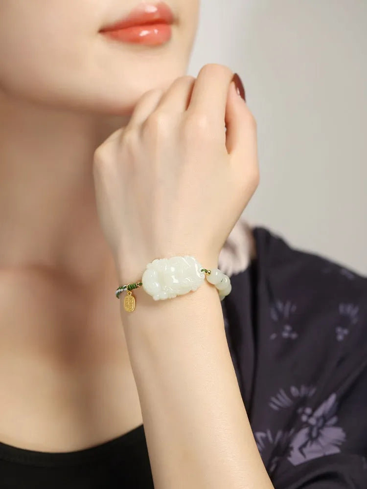 Close-up of a Rabbit zodiac charm Hetian jade bracelet with red rope and S925 silver card.