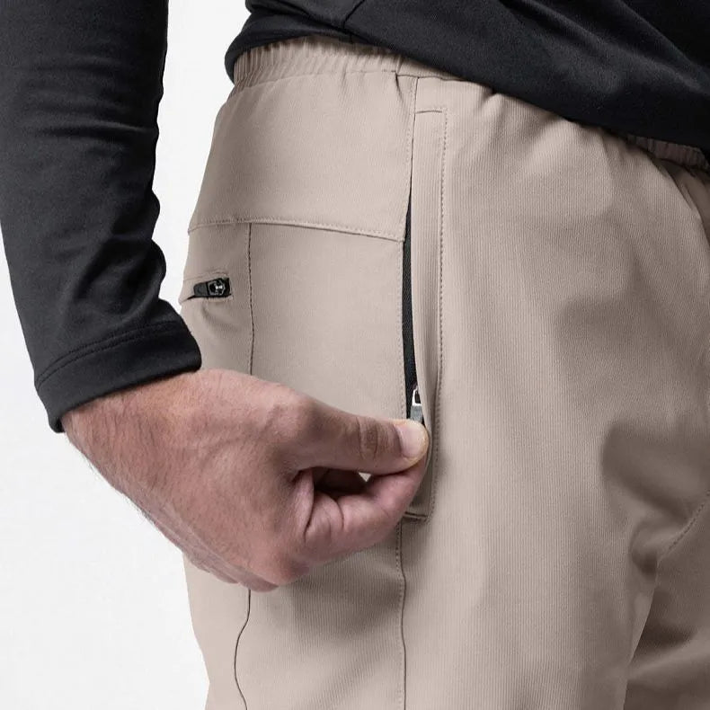 Man wearing dark grey loose-fit ankle-tied fitness trousers made of quick-drying polyester during a workout.