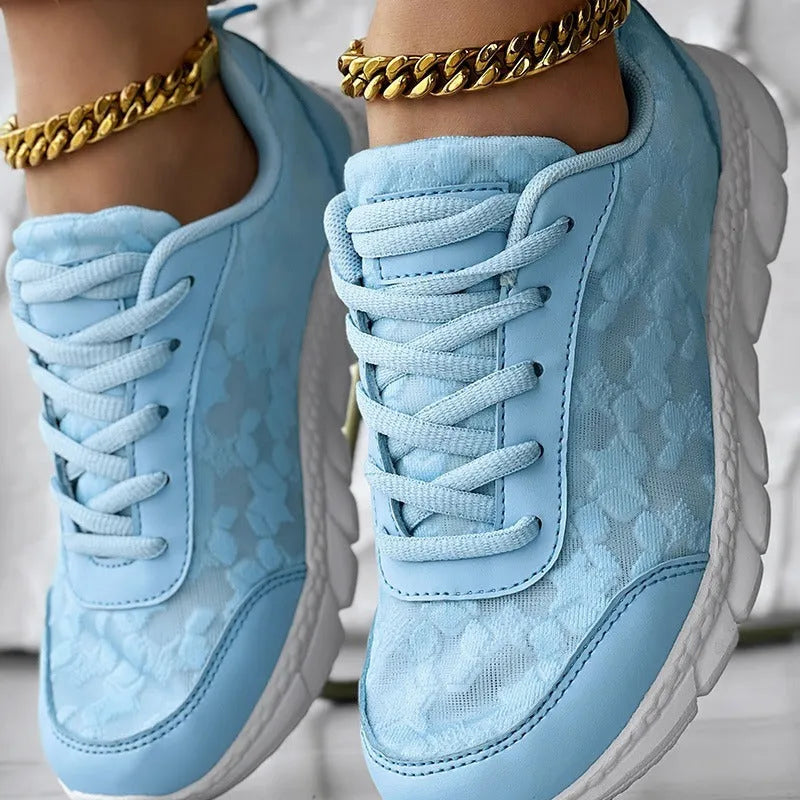 Women's white canvas running shoes with a flat heel and round toe on a plain background.