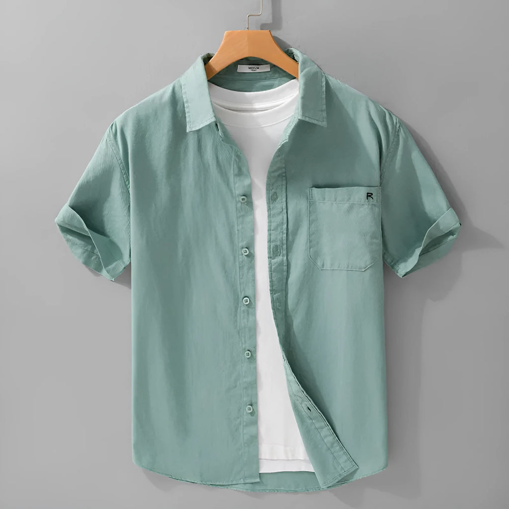 Men's light blue loose fit short-sleeved cotton shirt with a cardigan style front, laid flat.