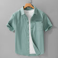 Men's light blue loose fit short-sleeved cotton shirt with a cardigan style front, laid flat.