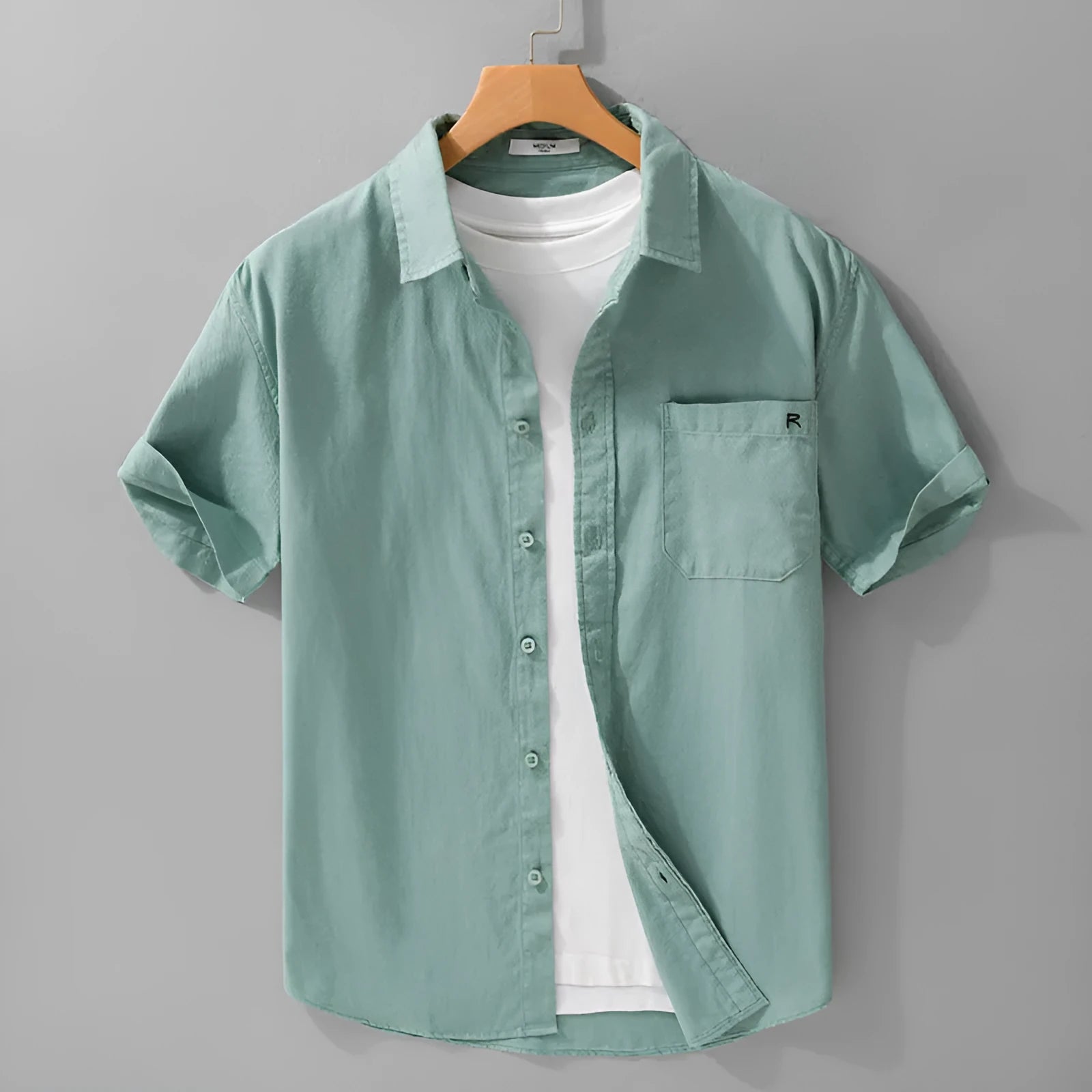 Men's light blue loose fit short-sleeved cotton shirt with a cardigan style front, laid flat.
