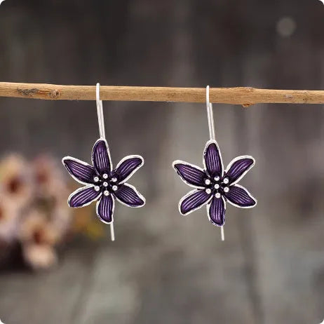 A pair of purple floral alloy earrings with a retro design on a white background.