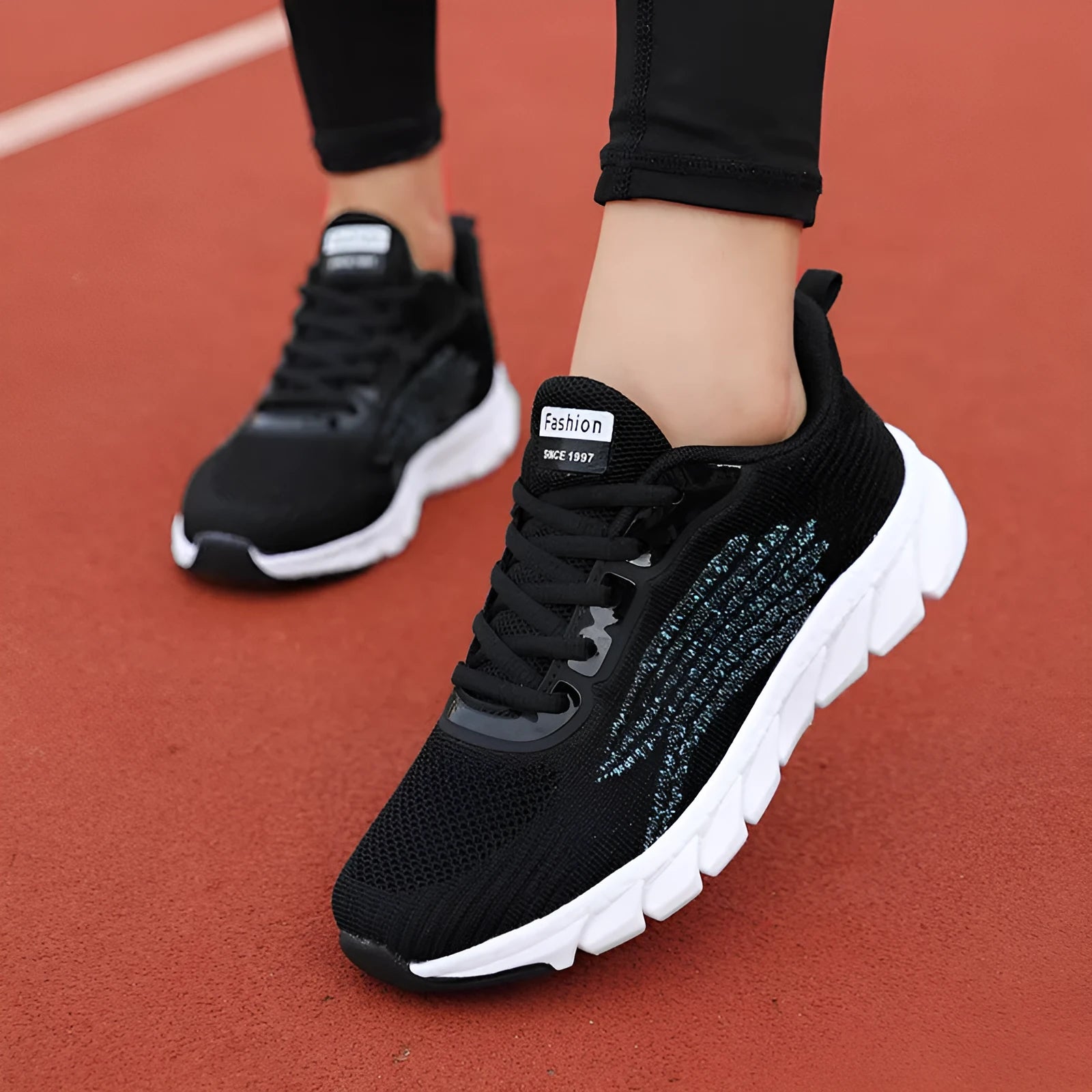 Women's low-top black and white casual running sneakers with MD sole and cross-strap detail.