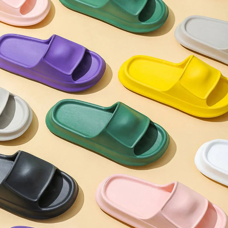 Pair of white EVA flip-flop slippers with a thick, textured sole on a tiled floor.