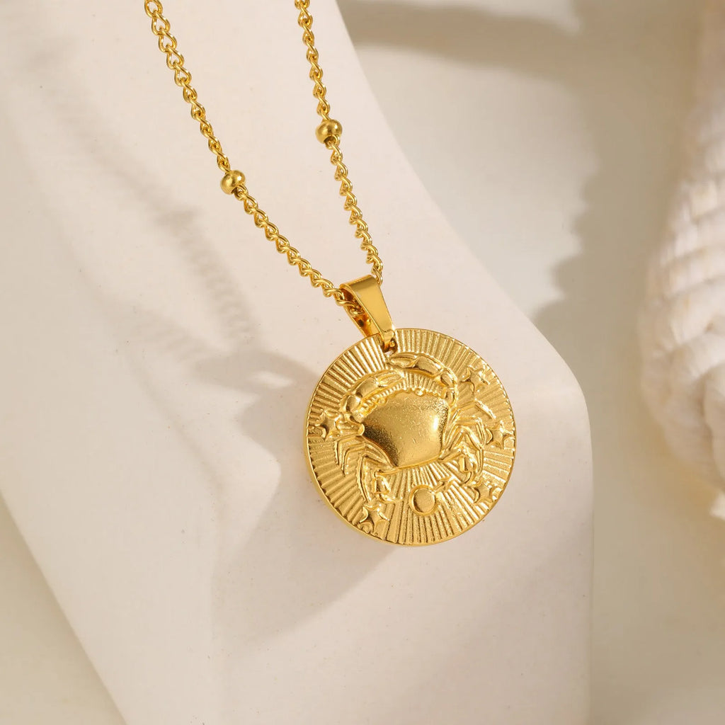 Stainless steel cross chain necklace with a geometric round bead pendant embossed with a zodiac constellation design.