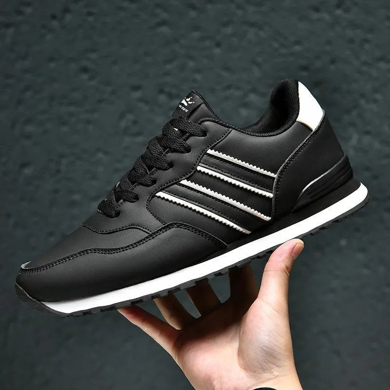 Men's black leather sports shoe with carved wing pattern detail on the side and a high heel.