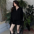 Women's creamy-white knitted suit set with geometric cable knit pattern, featuring a long sleeve top and elastic waist shorts.