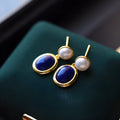 A pair of simple stud earrings with blue lapis lazuli pearls set in silver backs.